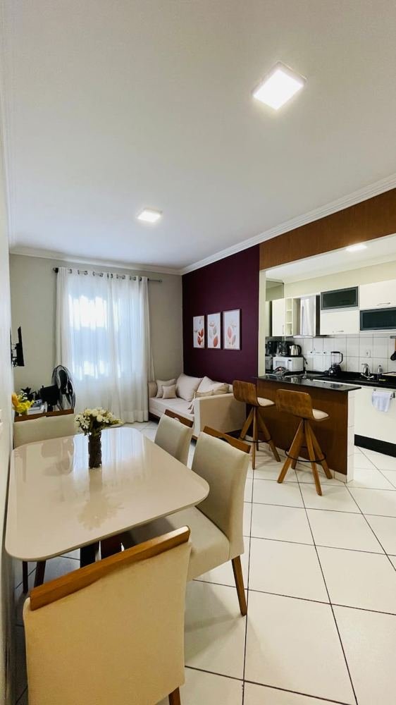 Sala integrada com cozinha, mesa de jantar e bancada do ape com horta
